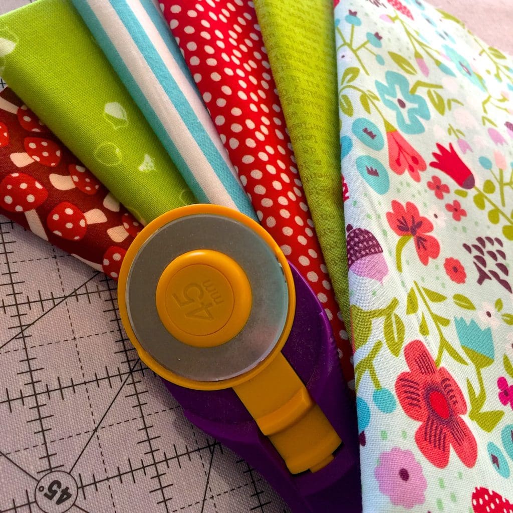 Stack of colorful fabric and rotary blade