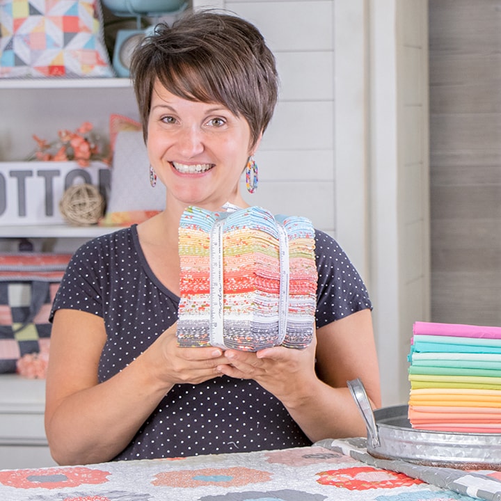 Corey Yoder poses with her Fat Quarter Bundle of Sugarcreek Prints fabric in the Fat Quarter Shop studio.