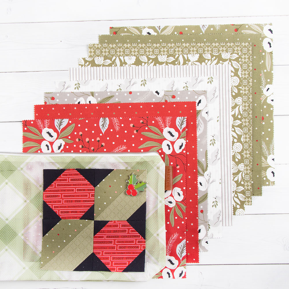 Different fabric swatches are displayed with the very first All the Trimmings block layered on top of the fabric. The block is a red and green holly leaf! 