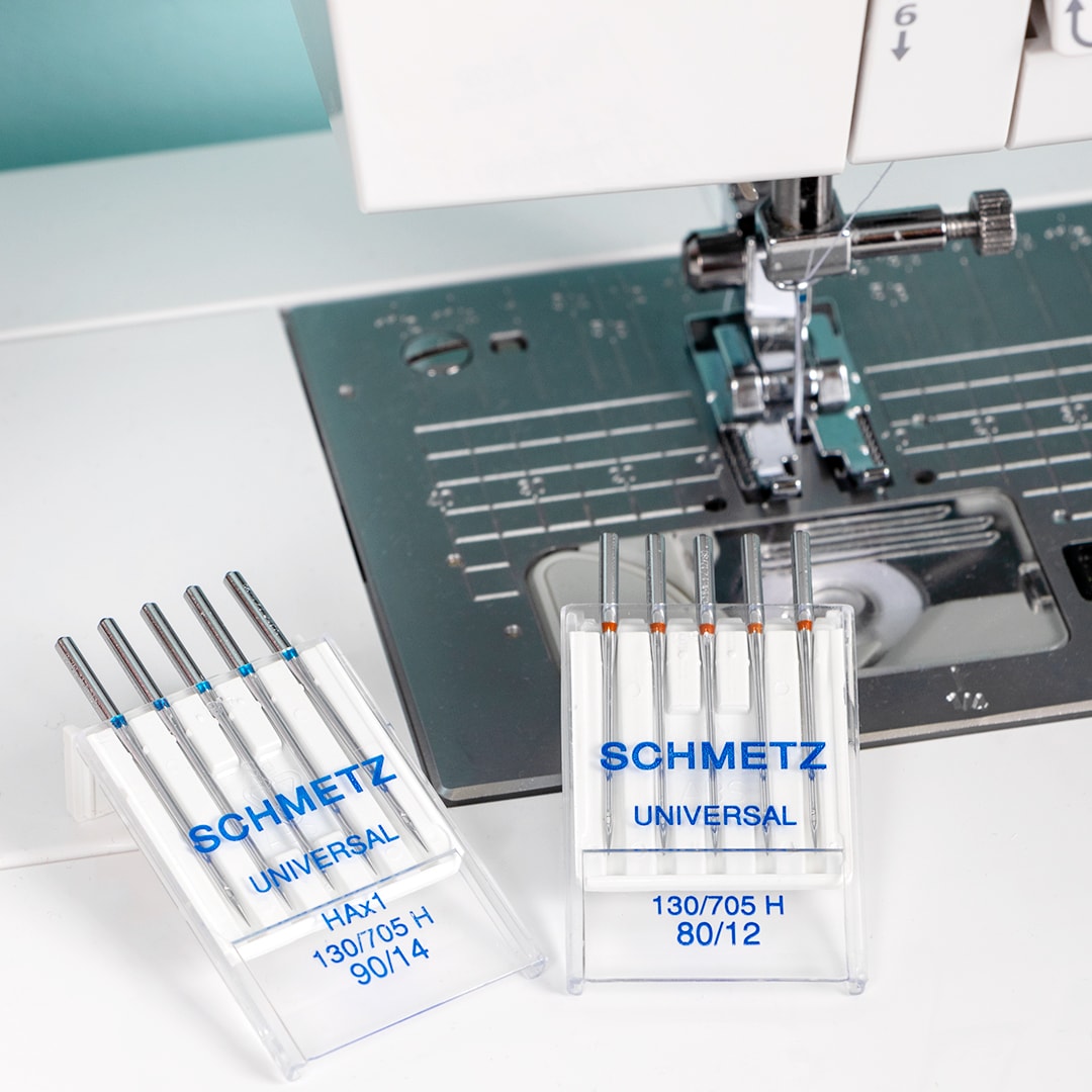 Close up of Schmetz universal sewing machine needles with a background of sewing machine