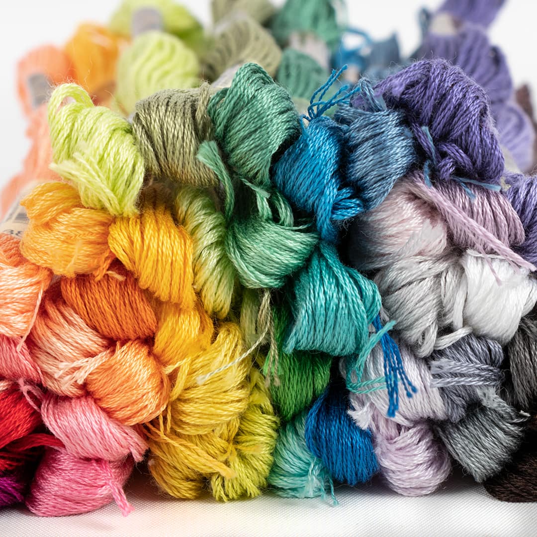a close up of pastel rainbow thread colors