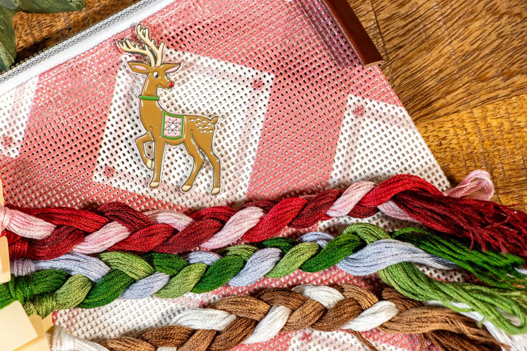 Up on the rooftop stitch along cross stitch supplies including needle minder, floss, and mad for plaid bag