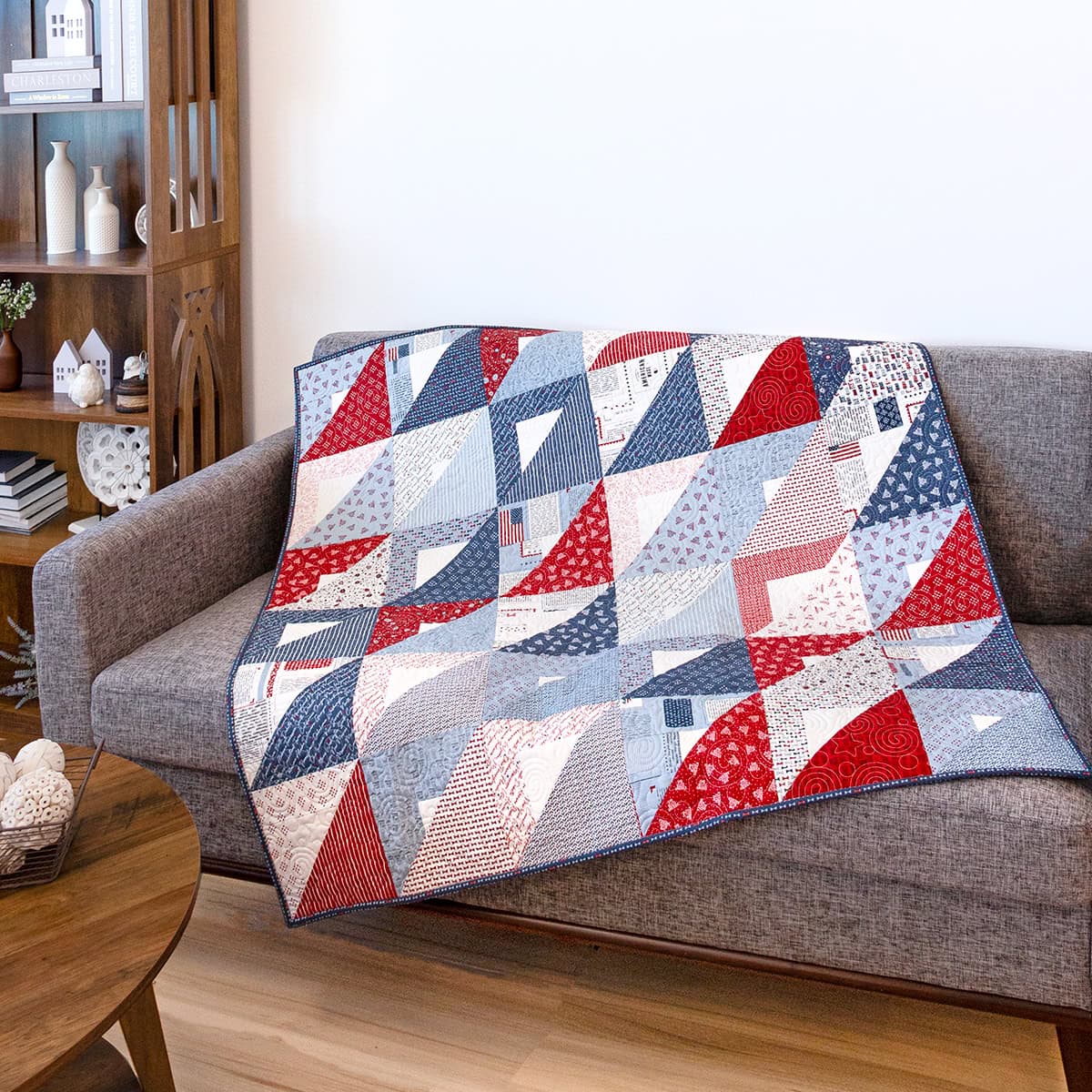 Image of the Layer Cake Pocket Squares quilt displayed on a gray couch